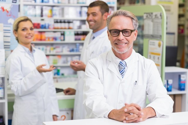 Team of pharmacists smiling at camera